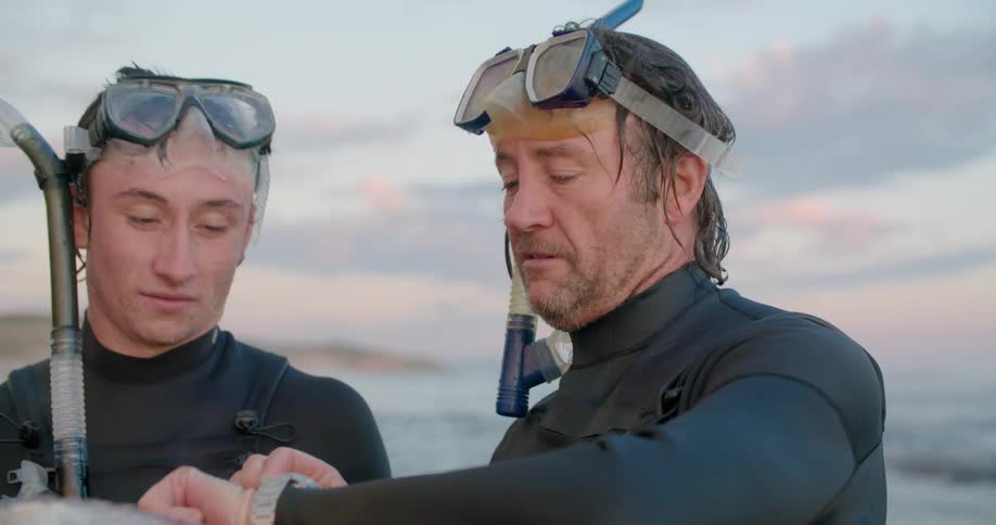 Father and son sharing a moment after spearing a fish near the ocean