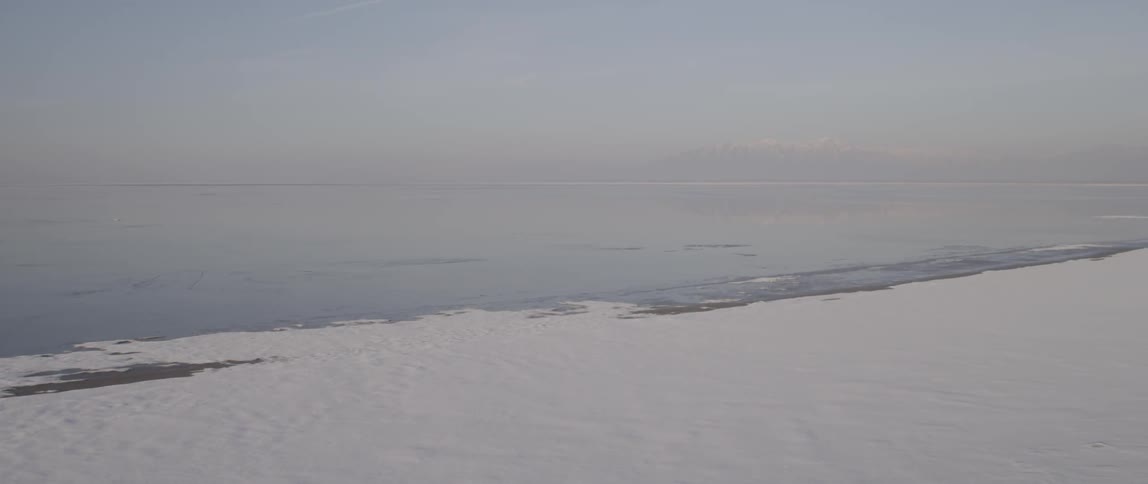 A snow covered beach during the day