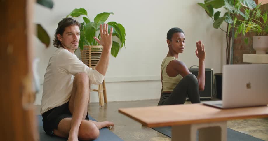 Young couple practicing yoga on the floor of the living room