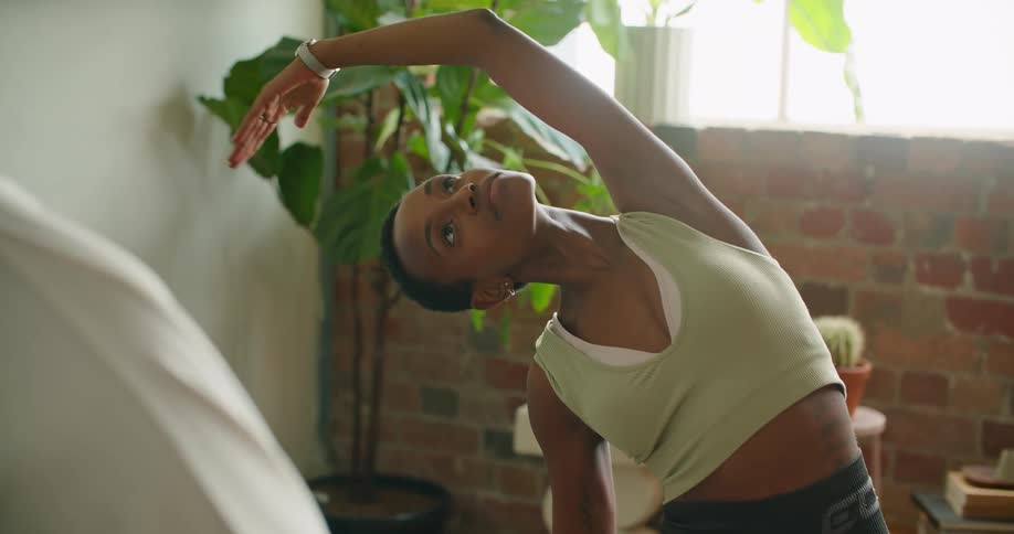 A man and woman are doing yoga in a room during the day