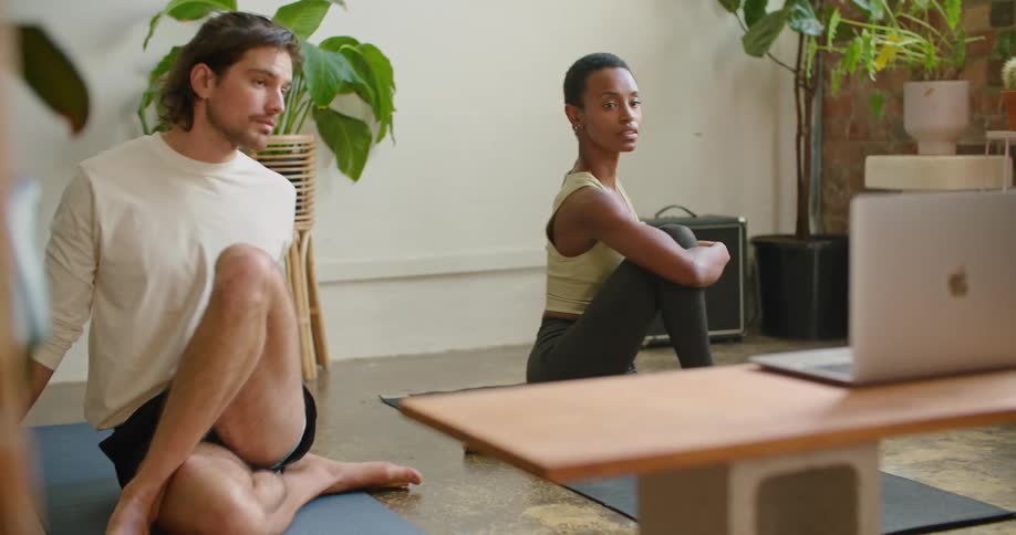 A man and woman are stretching in a room together