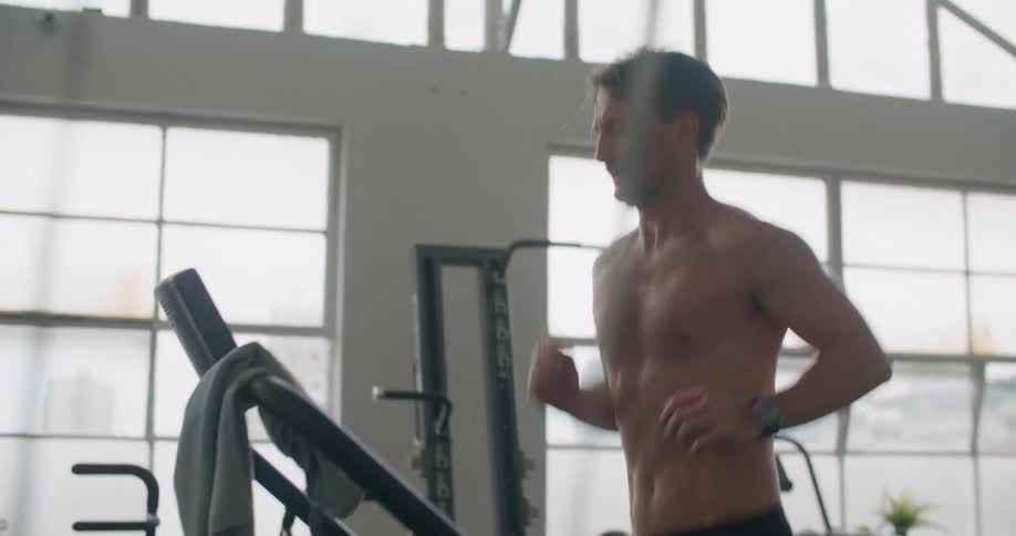 A man running on a treadmill in a gym
