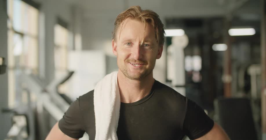 Man sweating after exercising on the gym looking at the camera