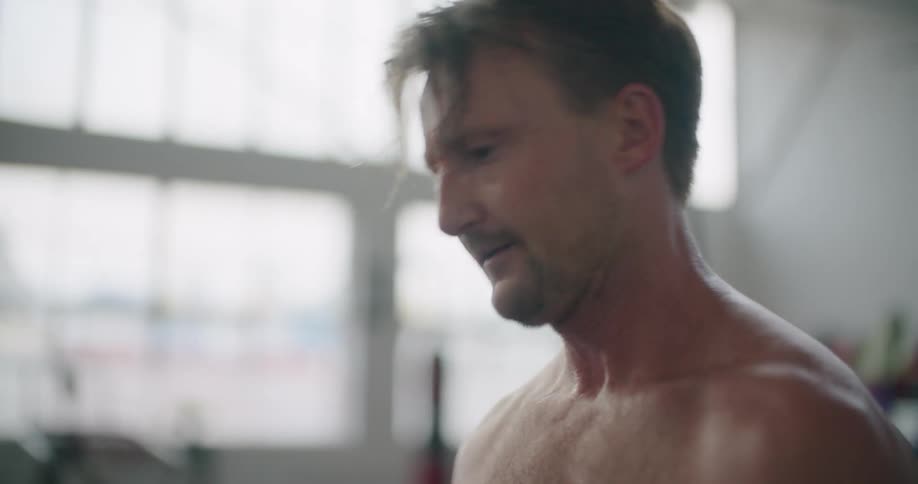 A man struggles as he does a barbell curl