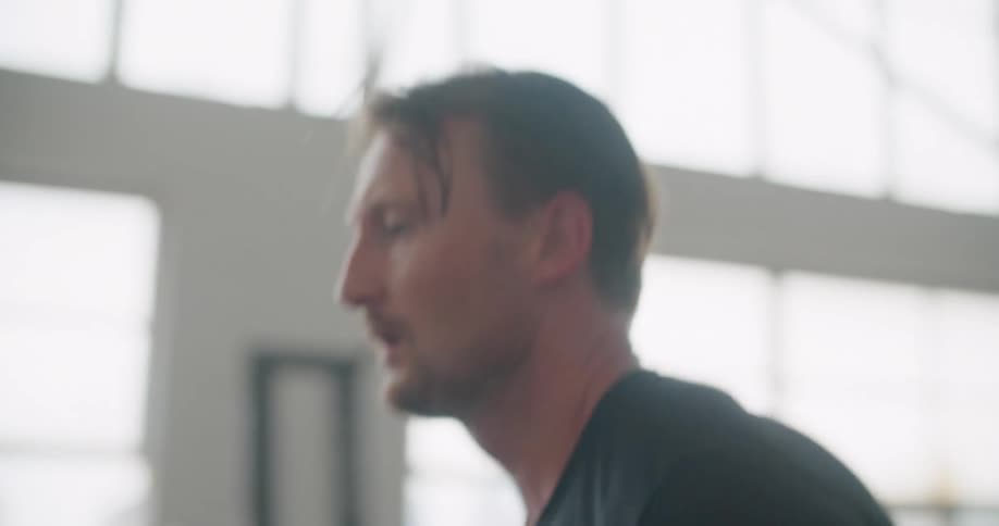 A man changes speeds on a treadmill while running at a gym