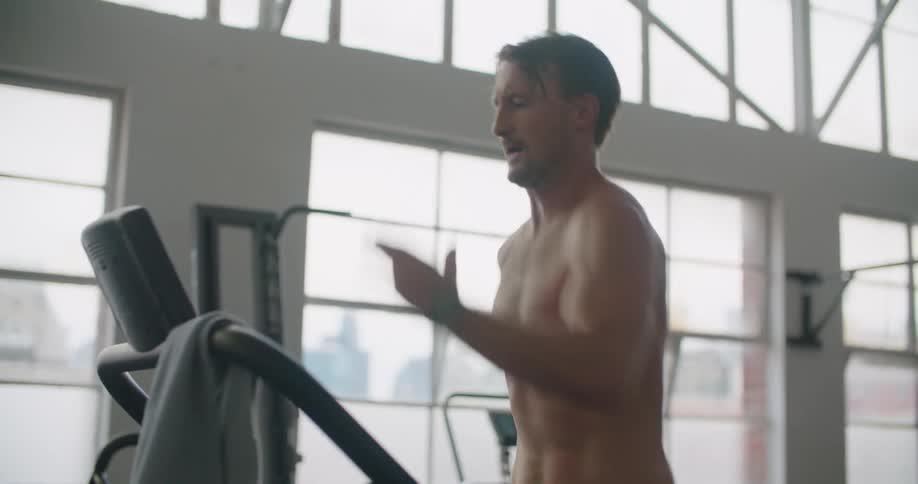 A man running on a treadmill in a gym room