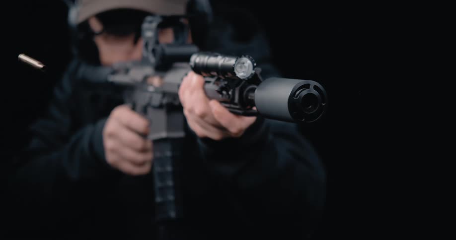 A man fires his rifle and the shell flies away