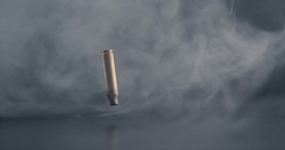 A bullet casing falling to the ground in slow motion