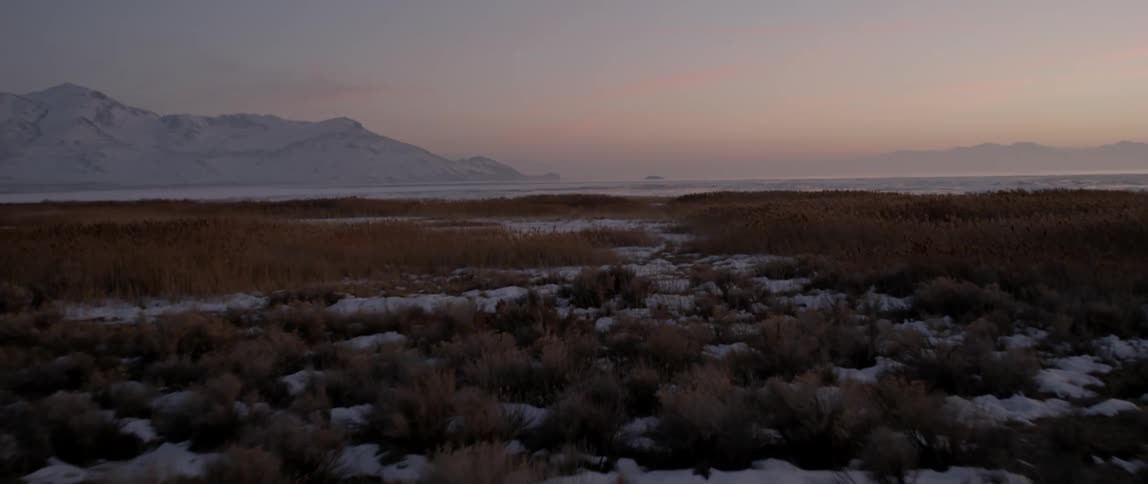 A snowy field during sunset