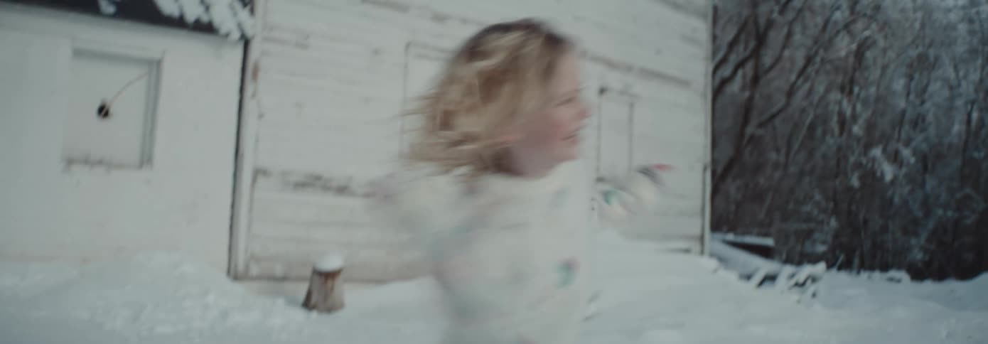 Young siblings playing with snow outside the house at winter