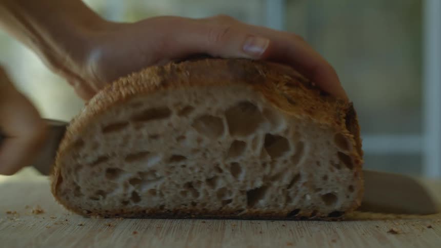 A woman cuts bread at home