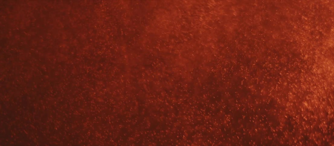 A dark room suddenly lights up in an orange hue and a clear mist scatters across