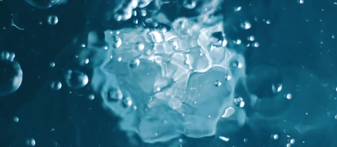 Bubbles move up to the surface of a clear liquid
