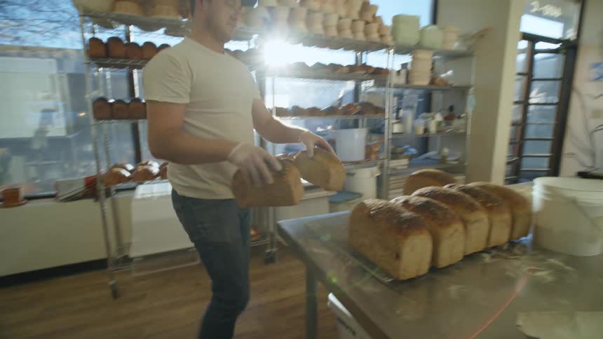An employee moving bread in a bakery