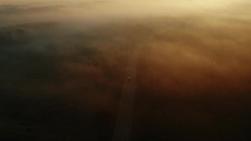 Aerial view of a road on a rural countryside under the fog in the morning