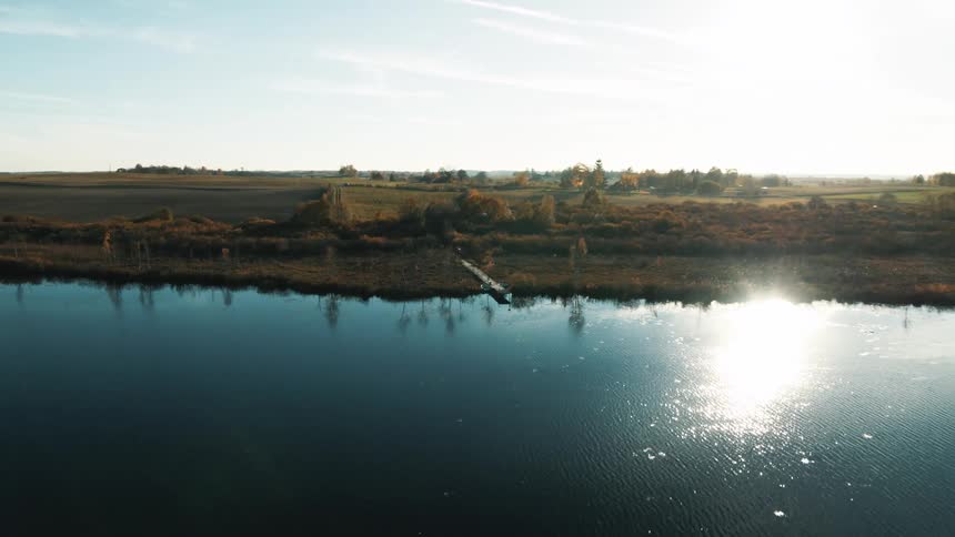 Lake with trees around it and the water reflecting the sunlight