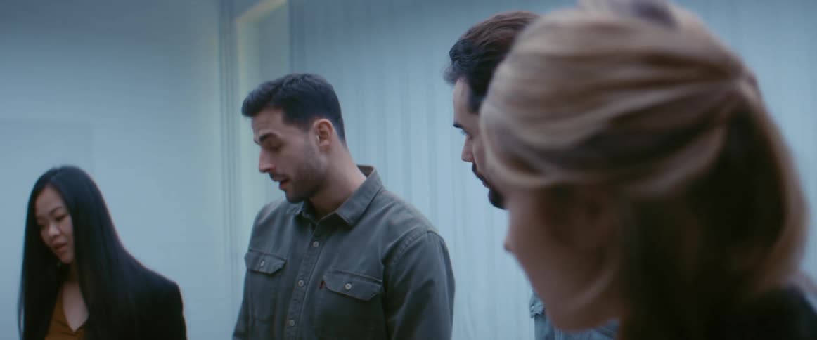 Coworkers nodding while standing around in conversation