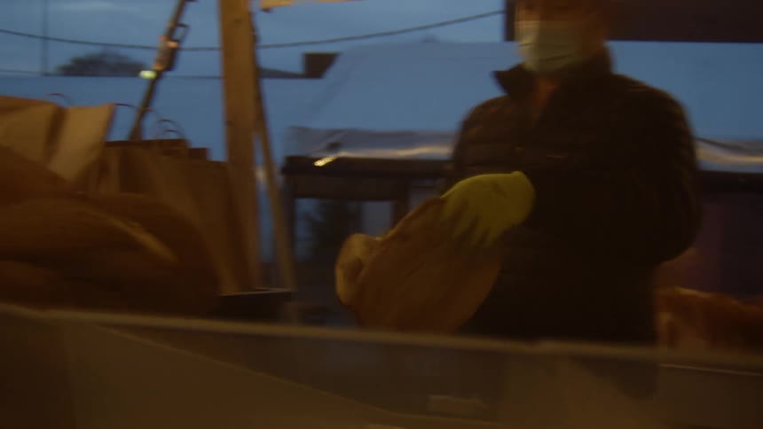 A person moving things in a tent area at night