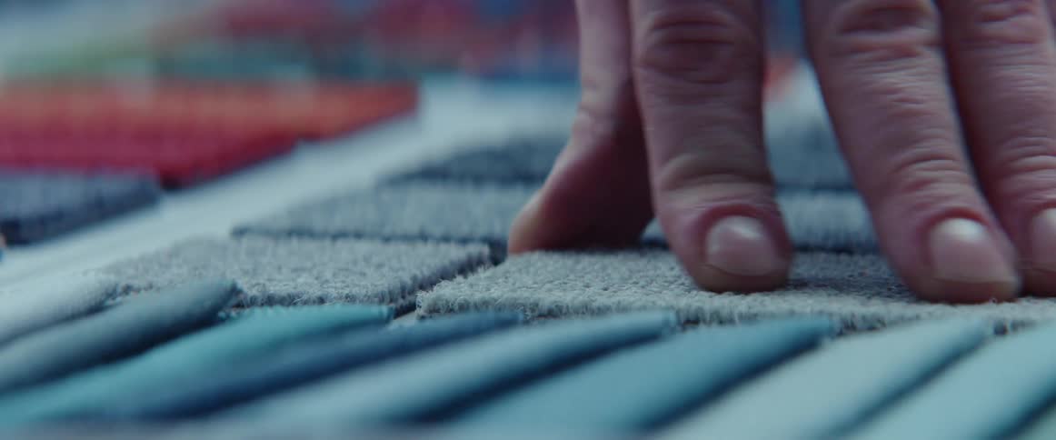 A man touches carpet samples
