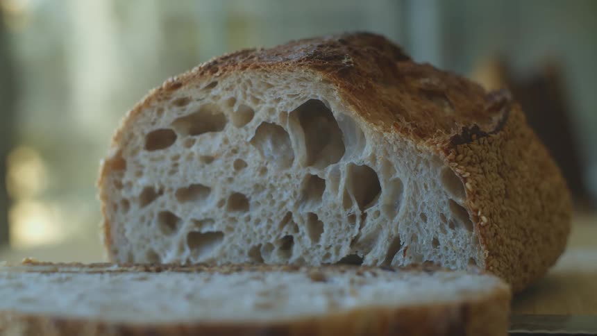 Loaf of homemade bread sliced over a table at home