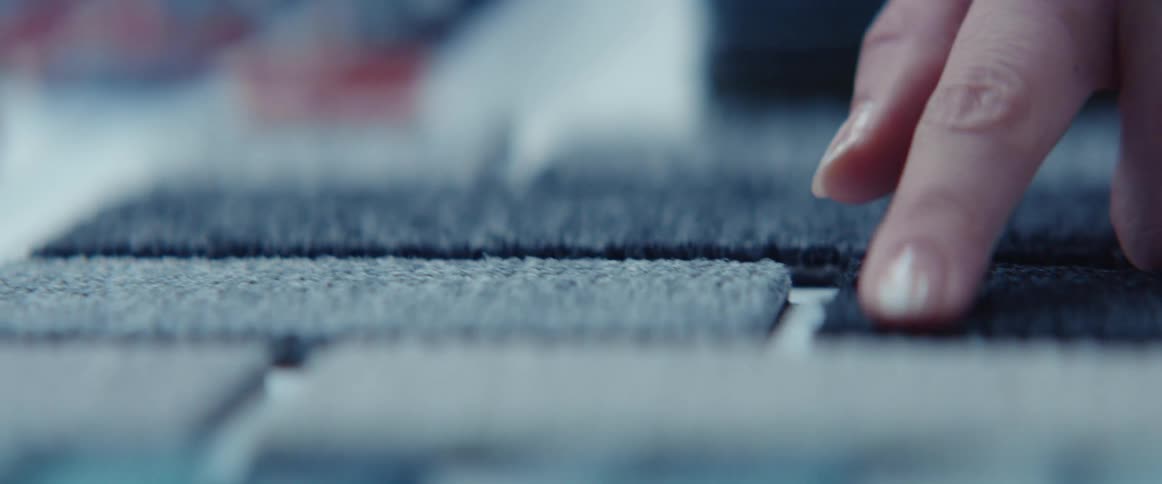 A person touching fabrics on a table