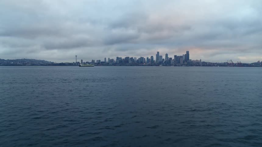 Flying low over Elliott Bay with a tilt up reveal of the Seattle skyline at dawn