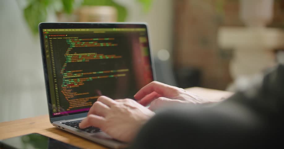 A man is typing code on his laptop