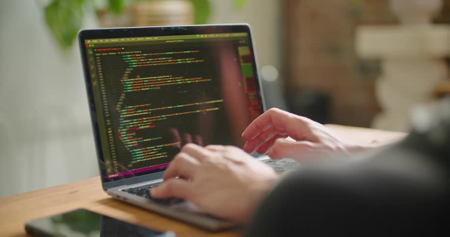 A woman in an office types on a laptop