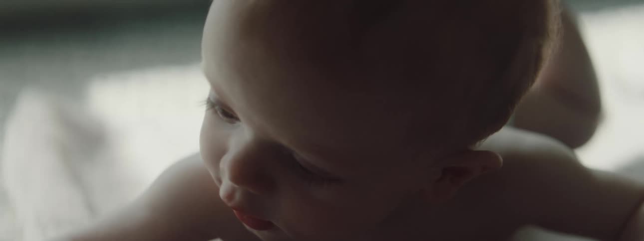 Baby wearing a diaper laying on a towel on the floor