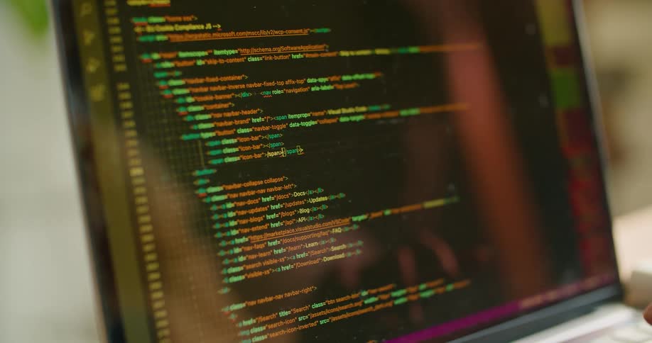 A person writing a computer program on a laptop