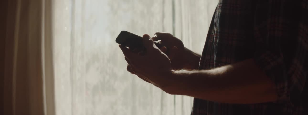 A man talks on his cell phone by the window