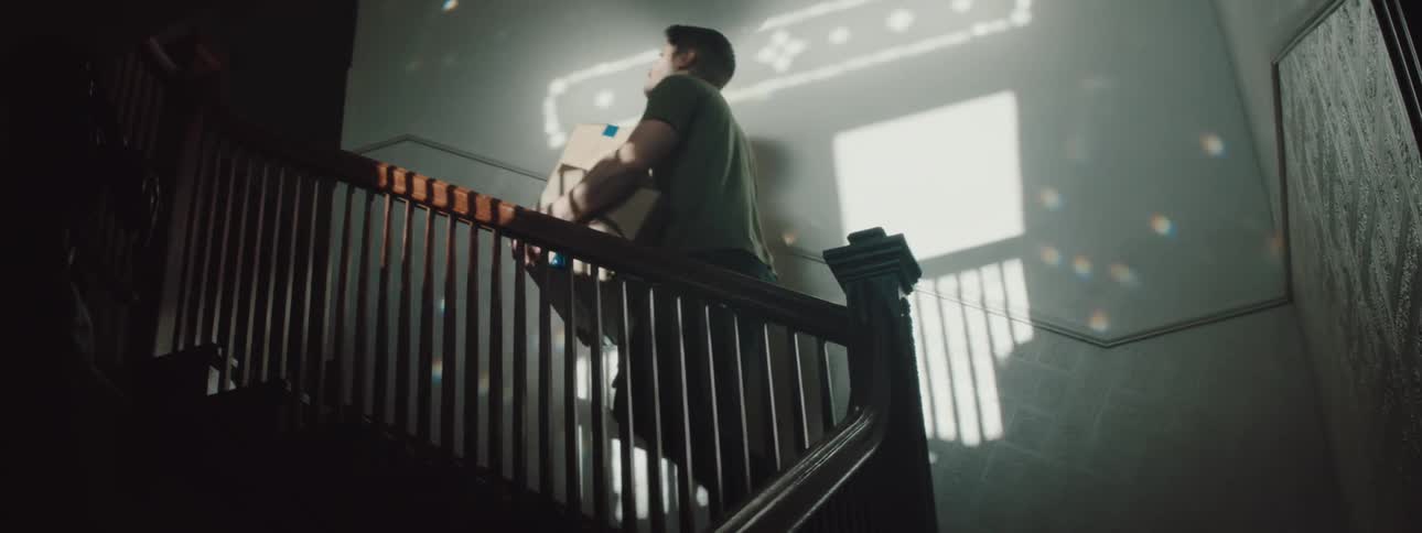 A man carrying boxes up a staircase