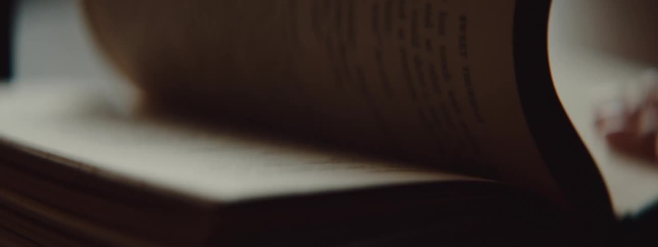 A person in a room flipping pages in a book