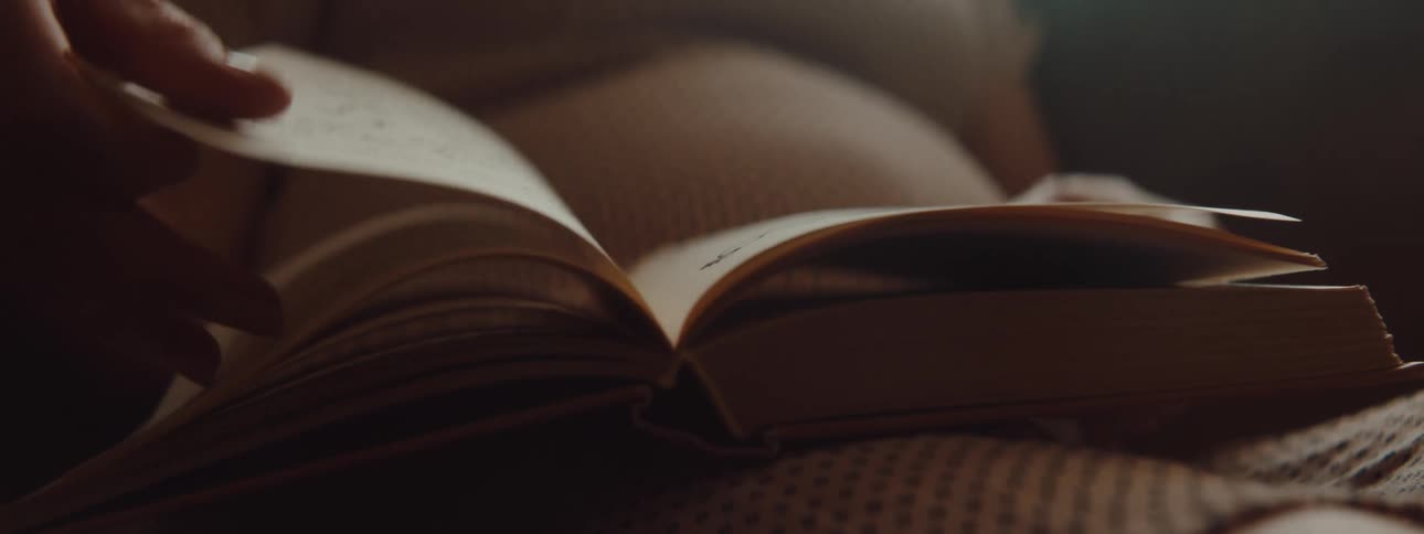 A hand turning pages in a book