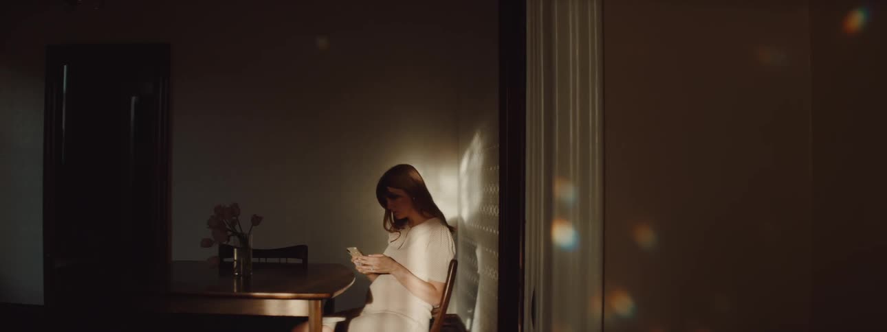 A woman is sitting at a table in her dining room