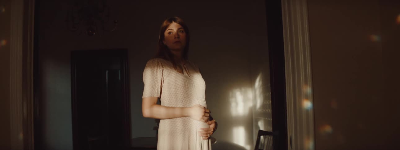 A pregnant woman is standing in a room
