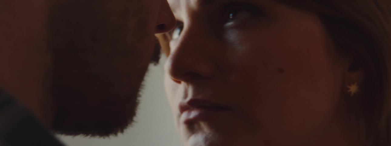 Couple stand close to each other looking into each others eyes then leaning heads together