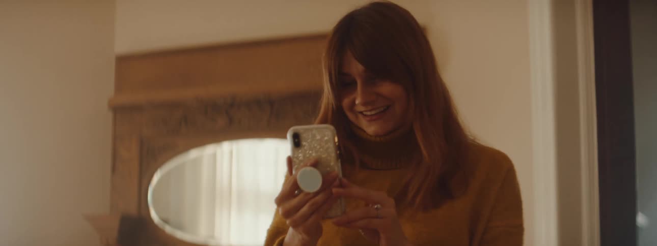 Woman walks around home talking via video call on mobile phone