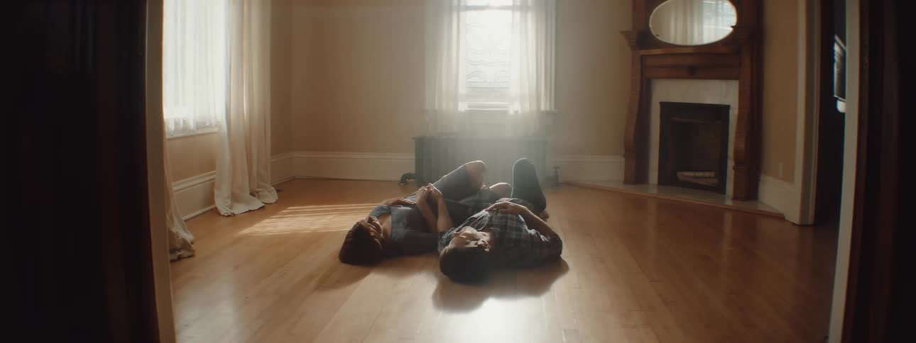 A man and woman laying on a floor of a room relaxing