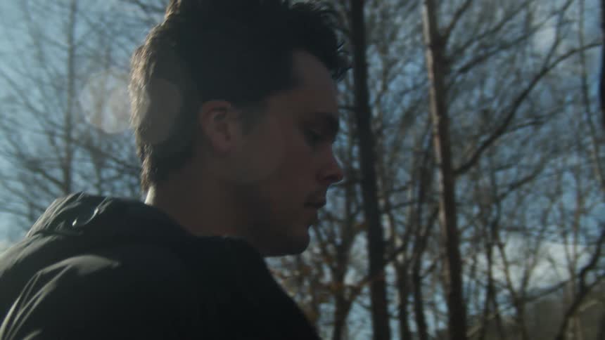 A man is walking past the trees