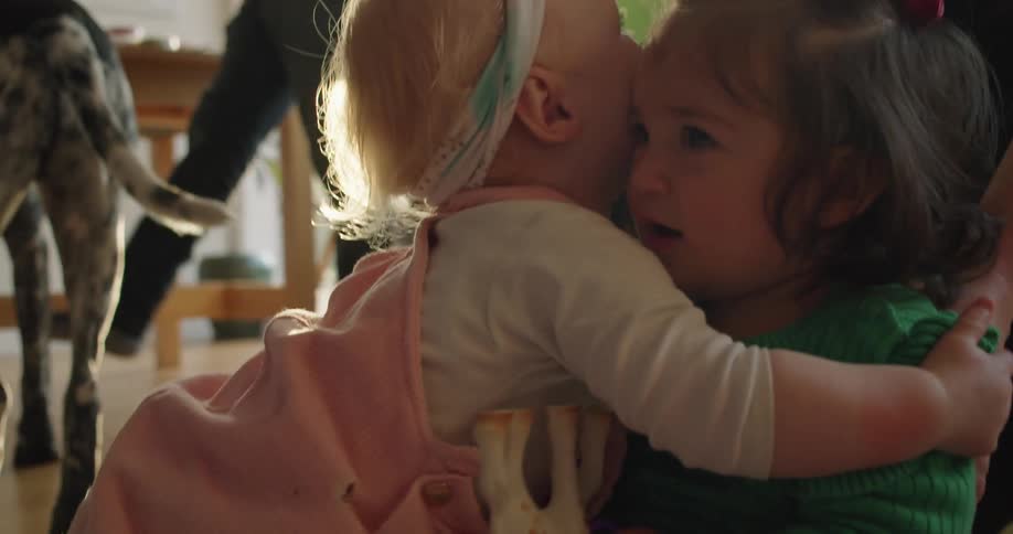 Two babies hug at a party