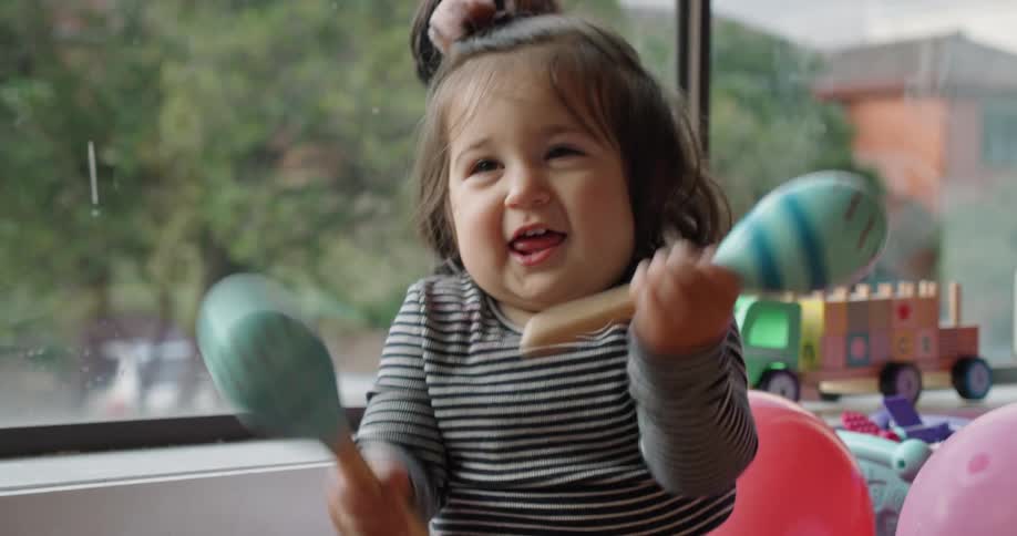 A baby playing with maracas