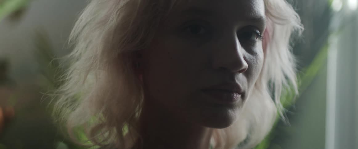 Blonde woman looking at the camera is silhouetted