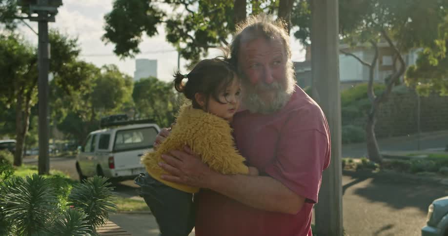 A father is standing outdoors and holding his child