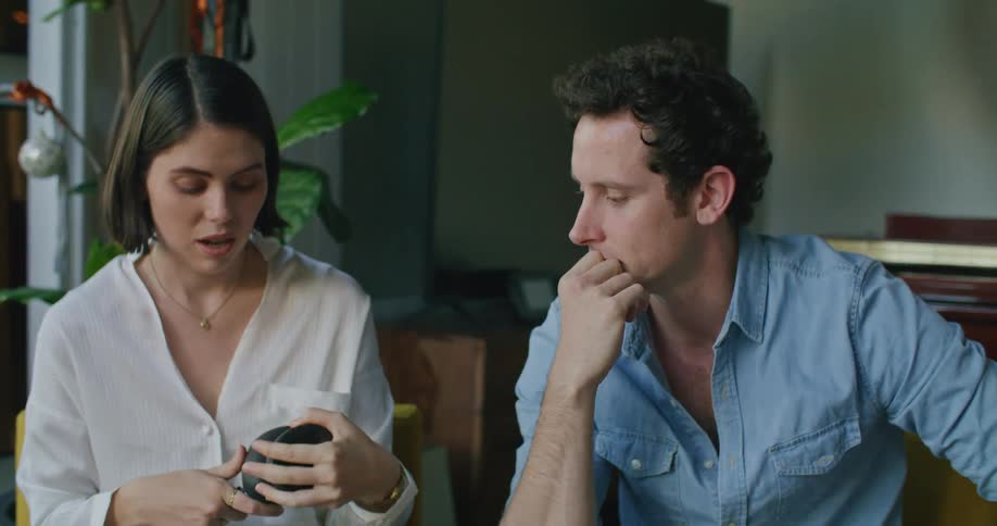 A man and woman use a laptop and look at a light