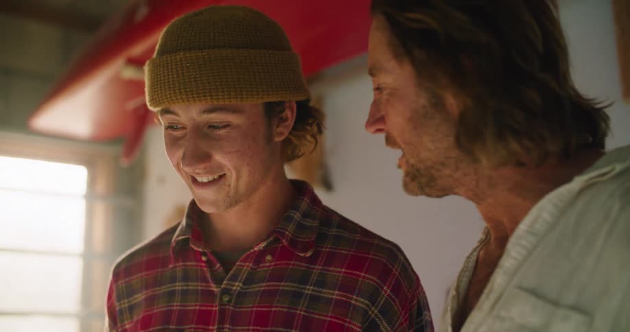 A man and teenager talk together and laugh