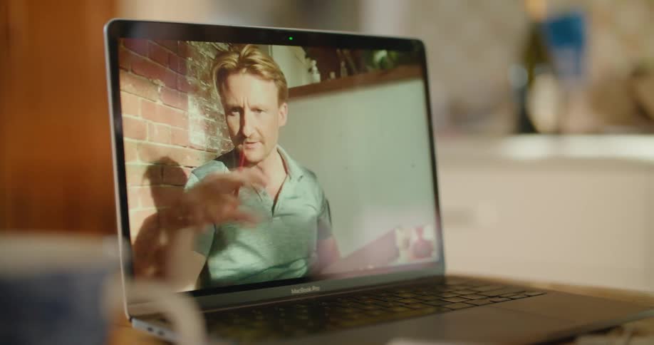 A person in a room using a laptop on a table with a mug