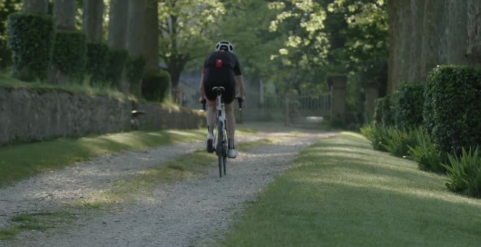 A man is riding a bike down a dirt trail