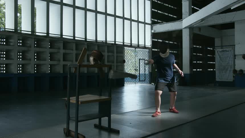 A man practices sword fighting indoors