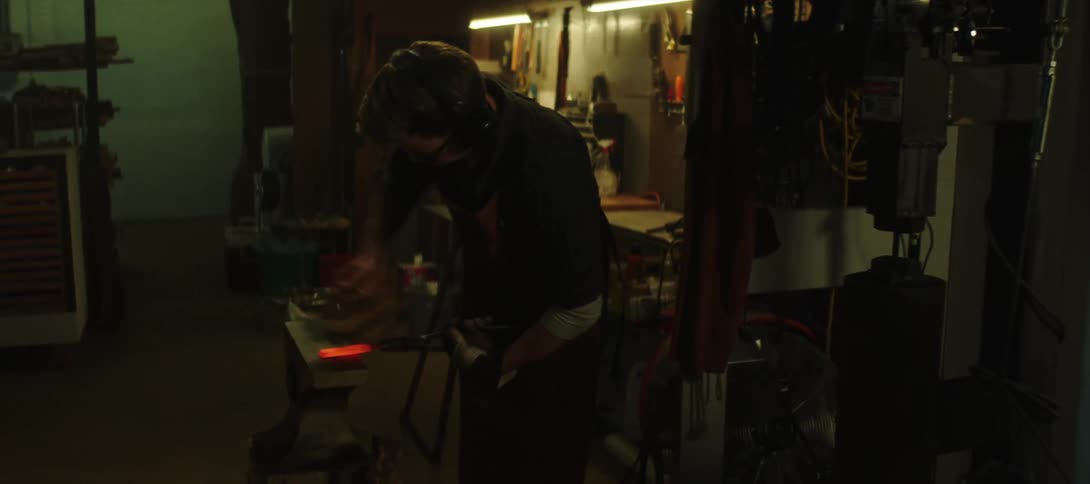 A blacksmith is working in the shop